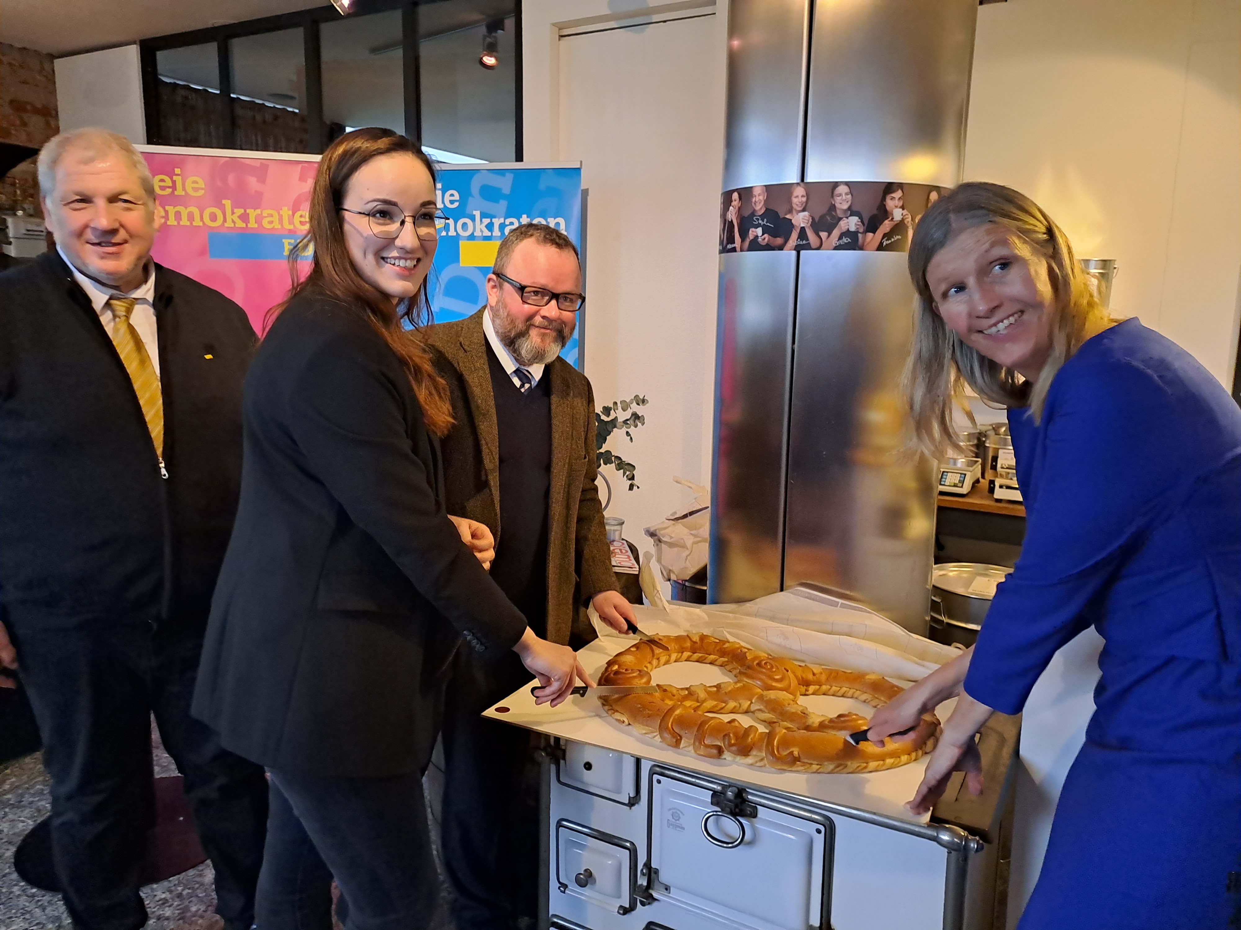 Der Kreisvorsitzende des FDP Kreisverbands Rastatt, Lutz Jäckel, die Landtagsabgeordnete Alena Trauschel (Wahlkreis Ettlingen), der Landtagsabgeordnete Christian Jung (Wahlkreis Bretten) und die Bundestagsabgeordnete Ann-Veruschka Jurisch (Wahlkreis Konstanz) (von links nach rechts), bei dem traditionellen Anschnitt der Neujahrsbrezel in der Rösterei Eisenwerk in Gaggenau (Foto: Simon Kübel). 